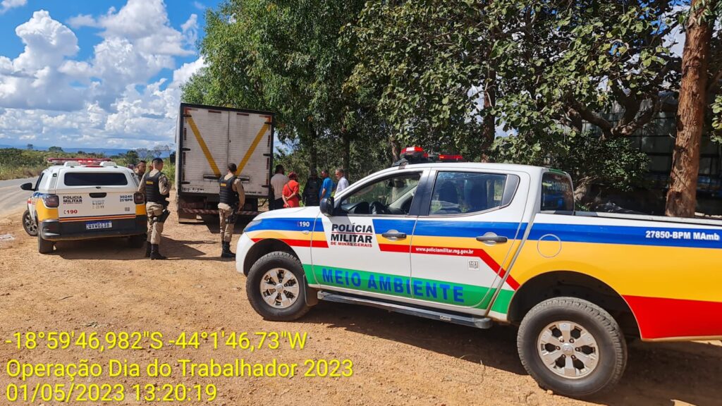 Caminhonete da polícia militar atrás de um caminhão em operação na cidade de Santana de Pirapama - MG