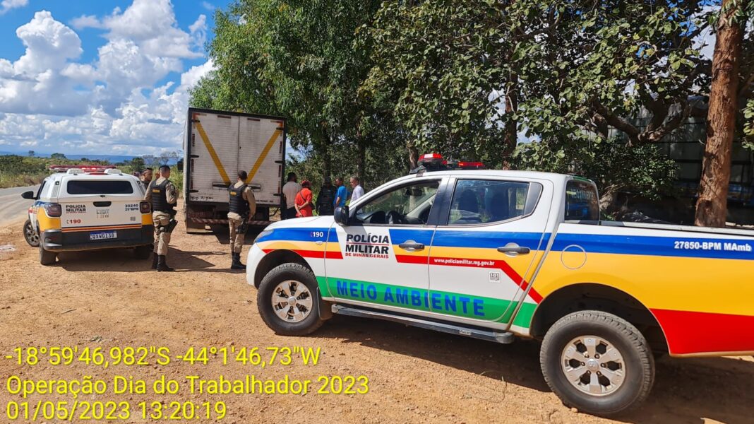 Caminhonete da polícia militar atrás de um caminhão em operação na cidade de Santana de Pirapama - MG